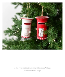 Detail of red and white metal mailbox ornaments hanging on a lighted Christmas tree