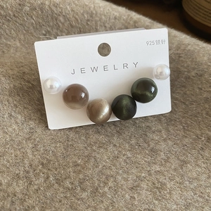 Gros plan de boucles d'oreilles en argent 925 avec perles de résine sur tissu chaleureux
