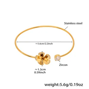 Macro shot of gold stainless steel bangle featuring zircon flower and starfish charm details