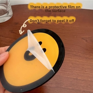 Detailed shot showing the protective film being peeled off the duck acrylic coaster