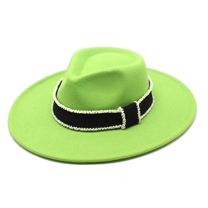 Detailed texture of neon green wool fedora with beaded black ribbon on wide brim