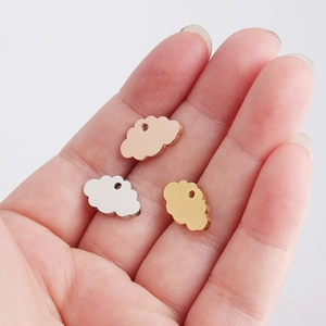 Detailed view of three metallic cloud charms in rose gold, silver, and gold finishes
