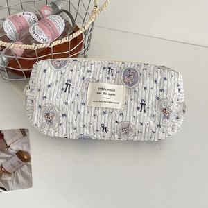 Detailed view of quilted cotton cosmetic bag featuring blue stripes and bear patterns