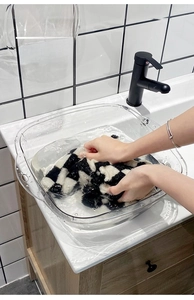 Close-up of a clear square acrylic washbasin with rounded edges for bathroom use