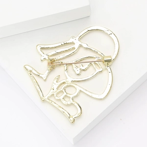 Abstract golden metal profile brooch featuring a silhouette portrait on white pedestal