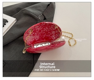 Detail show of marble pattern clutch with gold chain and clear accordion side