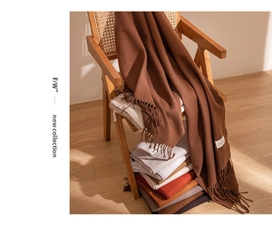 Detail of fringe edges and various warm color textures of cashmere-like scarves