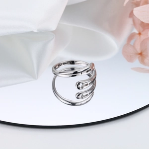 Dettaglio anello croce argento S925 con incisione Faith e I Am Enough su seta elegante