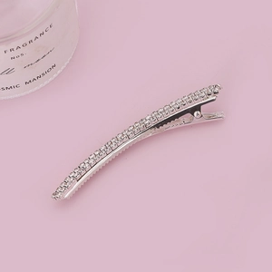 Elegant silver rhinestone bow hair clip on a minimalist pink background for women
