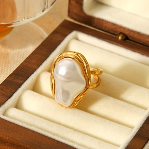 Détail d'une bague perle baroque dorée présentée dans un coffret cadeau de luxe