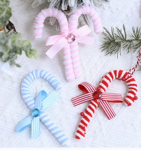 Macro shot of striped chenille candy cane ornaments with bows and gems for Christmas tree decoration