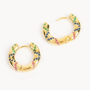 Detailed macro view of gold hoop earrings with spiral texture and colorful zircons
