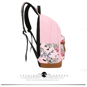 Detail view of pink canvas backpack featuring floral prints and reinforced brown suede bottom