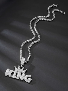 Close-up of hip hop silver necklace featuring a sparkling iced out KING crown pendant