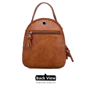 Rear view of brown textured leather bag showing the zipper pocket and fringe tassel