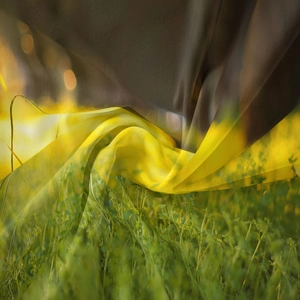 Close-up of lightweight yellow and grey silk chiffon fabric flowing in natural light