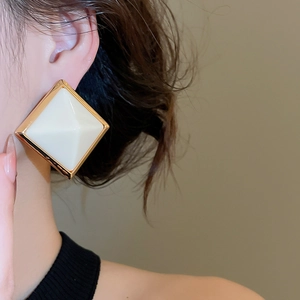 Gros plan de boucles d'oreilles rétro en résine losange avec cadre doré