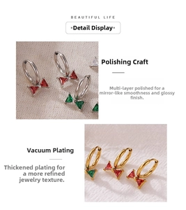 Detailed macro view of bow earrings with red and green zircons in gold and silver finish