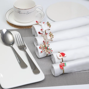 Close-up of festive metal napkin rings with reindeer and enamel Christmas designs