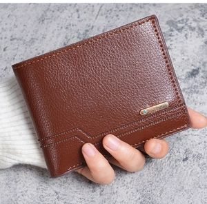 Detail of dark brown lychee grain leather wallet with golden metal bar and blue stone