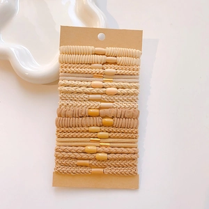 Close-up of earth-toned hair tie set including ribbed and braided elastic ponytail holders
