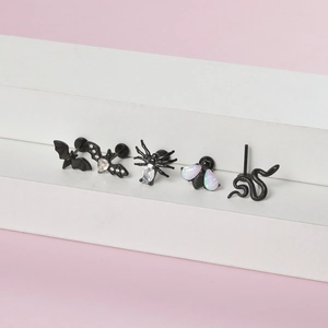 Vue détaillée des bijoux de piercing noirs en forme d'animaux avec opales et cristaux