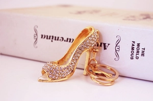 Close-up of golden high heel keychain with sparkling crystals on a book surface