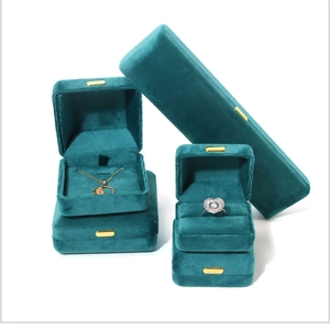 Detail of dark green velvet jewelry boxes for rings and necklaces with gold metal clasps