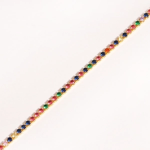 Detailed macro view of a gold tennis bracelet featuring colorful round cubic zirconia stones