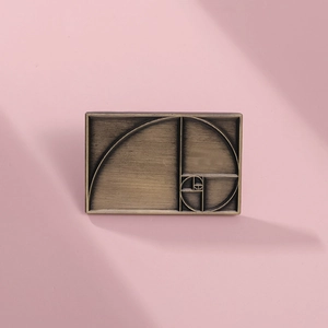 Macro detail of a vintage bronze rectangular brooch with golden ratio spiral engraving