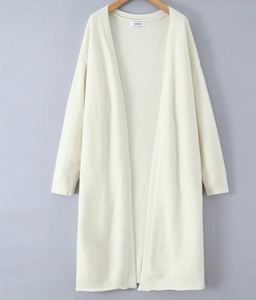 Detailed close-up of the textured knit fabric on a long cream-white cardigan