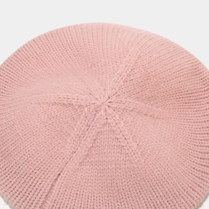Close-up of pink knitted beret showing detailed chunky knit texture and soft yarn fabric