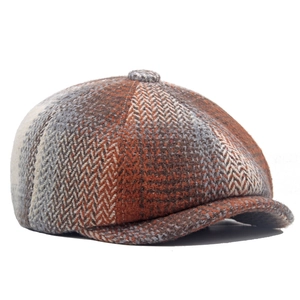 Detailed view of the herringbone wool texture and top button on a vintage newsboy cap