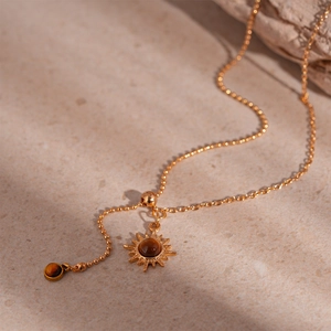 Detailed view of vintage sun flower pendant with tiger eye stone on gold plated chain
