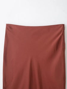 Detail of brick red satin skirt featuring lace trim and hidden side zipper closure