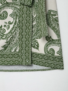 Detailed macro view of green paisley pattern and geometric prints on fabric hem