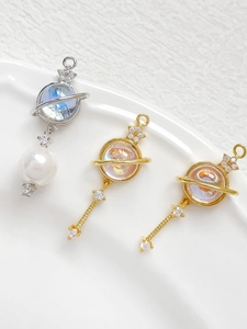 Macro shot of 14k gold-plated planet pendants with cat-eye stones and cubic zirconia details