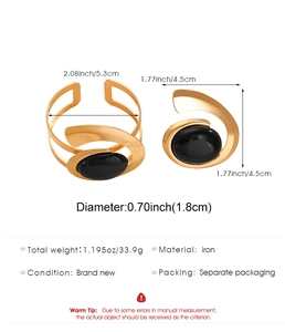 Macro detail of gold-plated iron ring featuring a large oval black gemstone and size specs