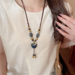 Détail d'un collier ethnique vintage avec un pendentif en forme de cœur en céramique bleu