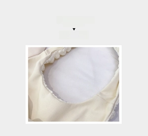 Detail of cream-colored pleated canvas shoulder bag showing rich twill fabric texture