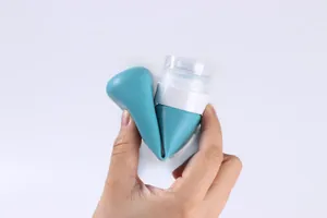 Flexible cyan silicone travel bottle being squeezed to show its durable and foldable texture