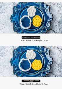 Detailed macro view of snowman and wreath shaped plastic cookie cutters and finished biscuits