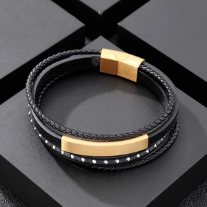 Macro detail of men's multilayer braided leather bracelet with matte gold magnetic clasp