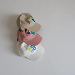 Close-up of three baseball caps with letter embroidery and distressed fabric details