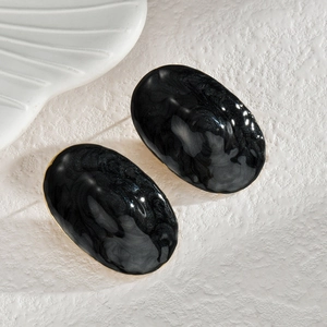 Élégantes boucles d'oreilles ovales texture marbre noir et bordure dorée