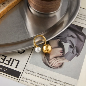 Minimalist gold titanium steel ring featuring a white pearl and polished metal bead