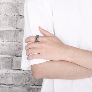 Close-up of punk style skull ring in silver steel on male model hand with white wall backdrop