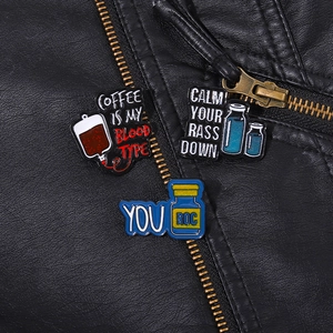 Gros plan d'épingles en émail avec slogans sur une veste en cuir noir aux détails nets