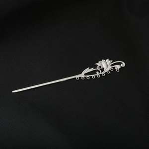 Close-up of silver lotus hair stick with hollowed details and hanging loops on leather