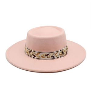 Detail of pink wool fedora with a patterned geometric jacquard hat band on white background